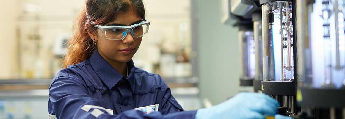 Laboratory technician / chemist working at viscosity analyzer machine (viscometer).